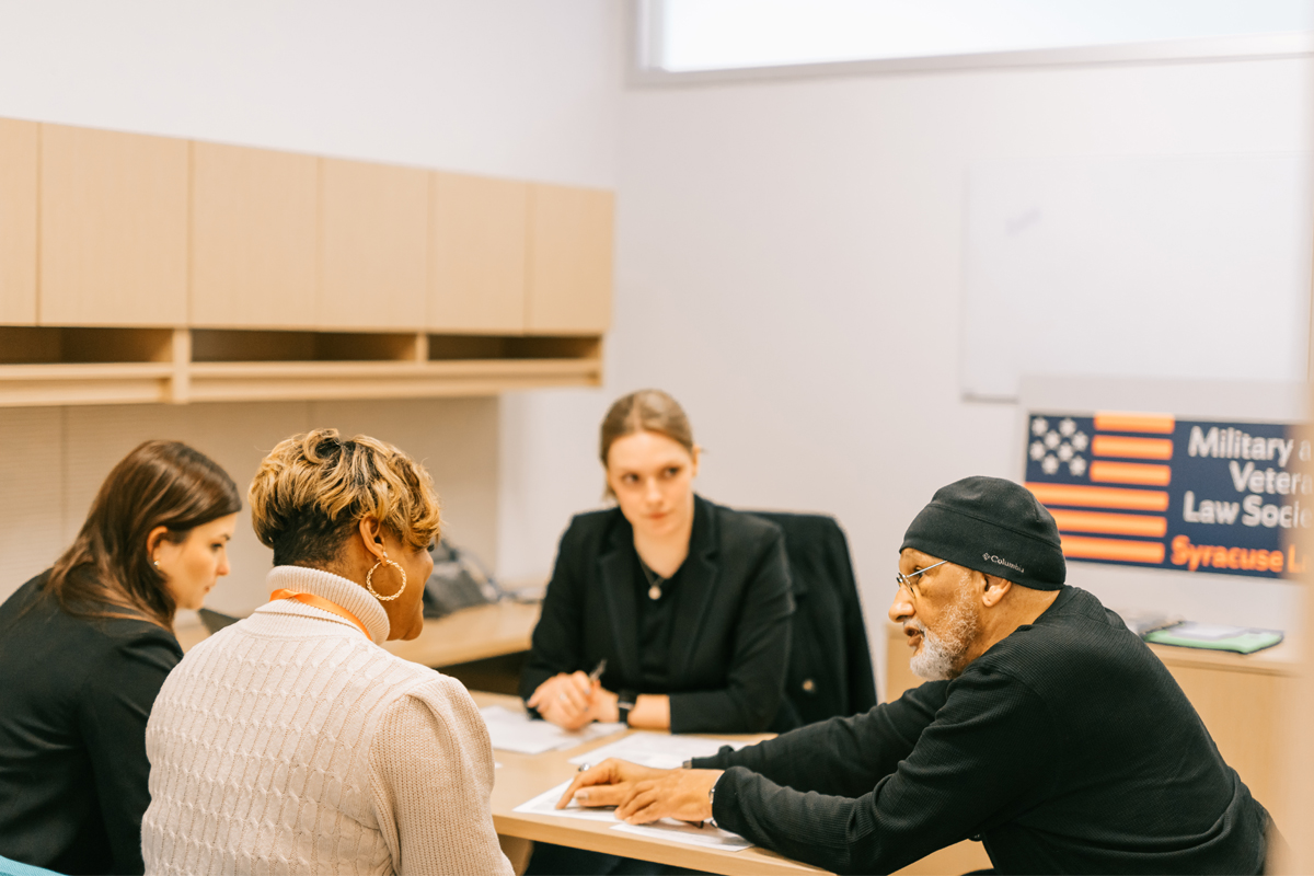 Law students at Veterans Legal Clinic helping a veteran with paperwork